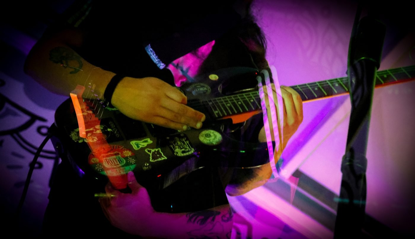 Detalle de guitarra en vivo con luces de colores, Kutral Ko
