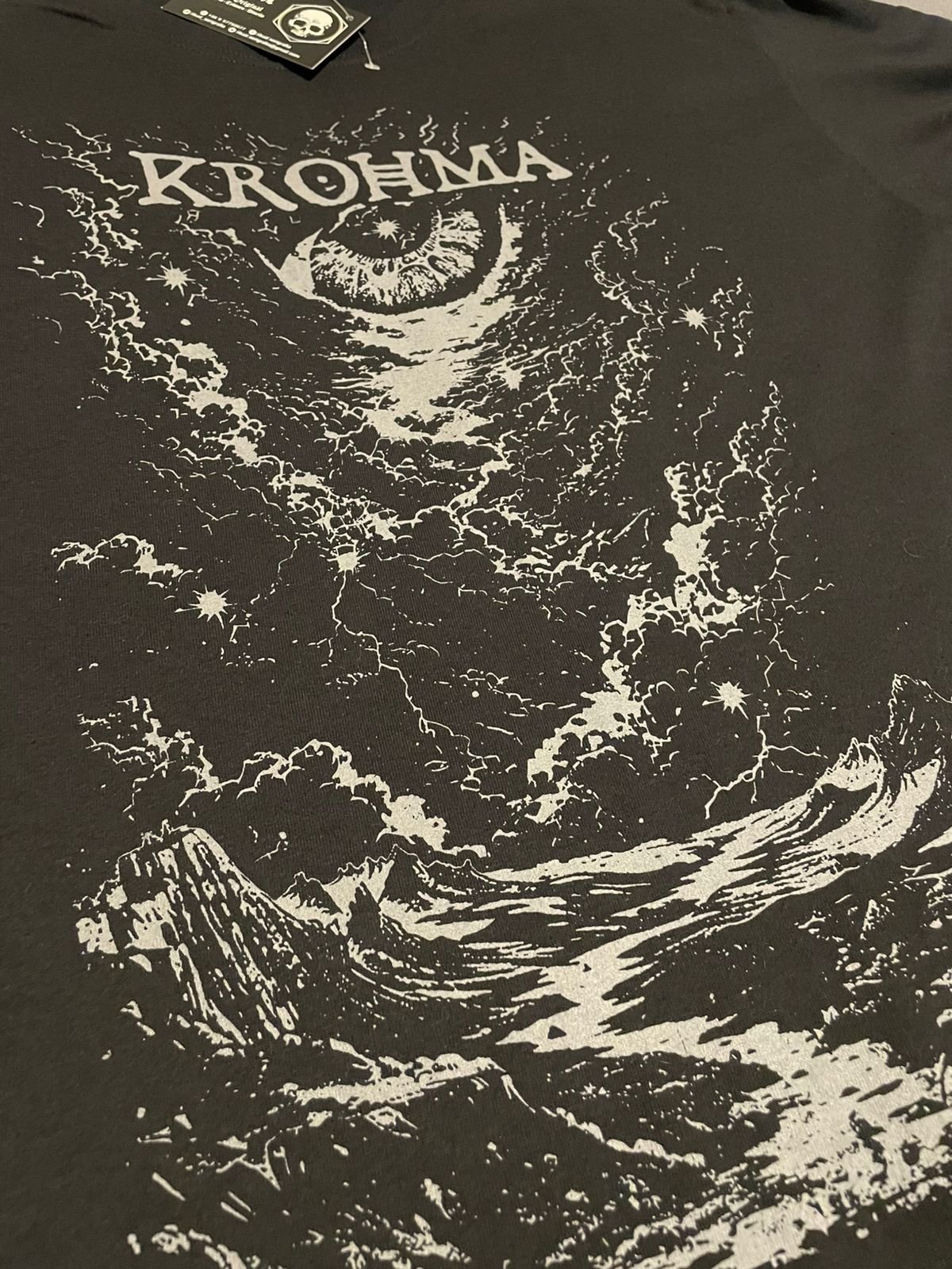 Estampado frontal de la polera nueva de Krohma: el ojo, la luna y la montaña