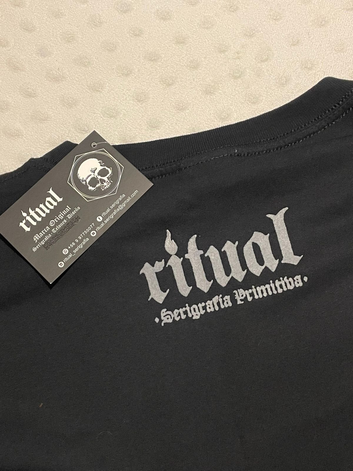 Etiqueta colgante y logo de Ritual Serigrafía Primitiva en el cuello