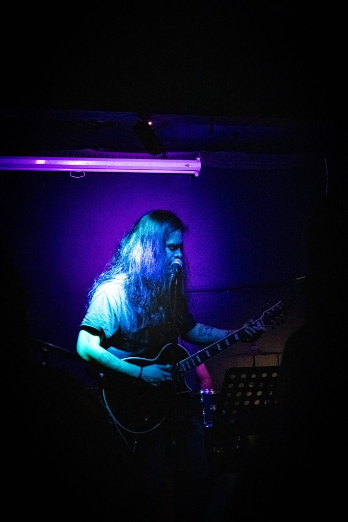 Nicolás Loyola cantando y tocando la guitarra en vivo